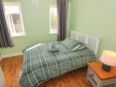 A bedroom with a bed and bedside table at Kathleens Cosy Apartment in Galway