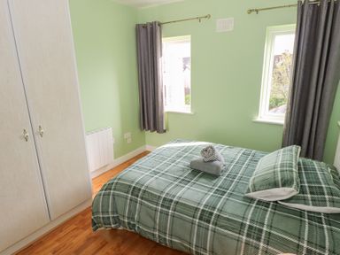 A bedroom with a bed and a wardrobe at Kathleens Cosy Apartment in Galway