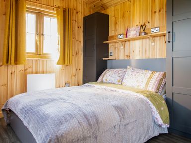 A bedroom with a bed and a window at Head For the Hills Glamping - Skylark Shepherd's Hut