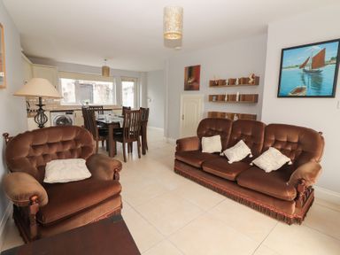A living room with a sofa and dining table at 1 Windermere in Kinvarra
