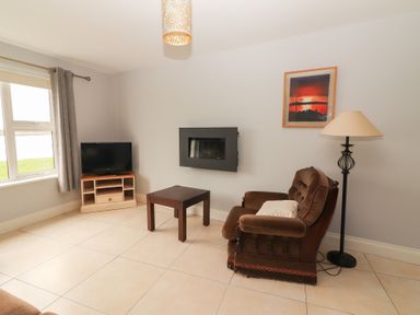 A living room with a television and a sofa at 1 Windermere in Kinvarra