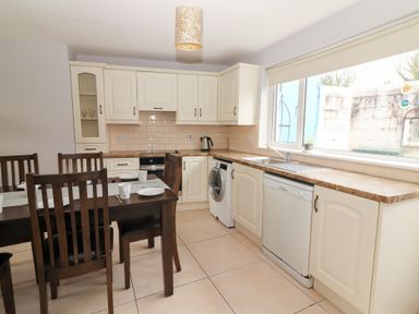 A kitchen with cabinets, dining table, and appliances at 1 Windermere in Kinvarra