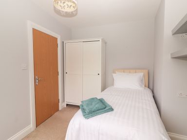 A bedroom with a single bed and wardrobe at 1 Windermere in Kinvarra