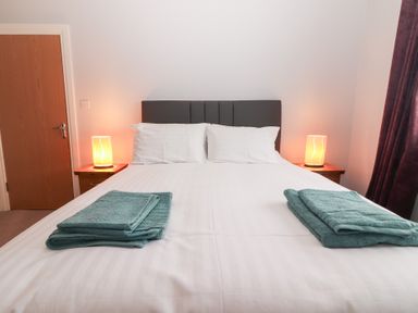 A bedroom with a bed and lamps on bedside tables at 1 Windermere in Kinvarra