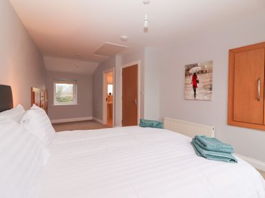 A bedroom with a bed and two towels at 1 Windermere in Kinvarra