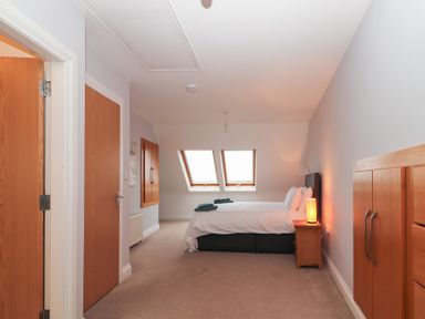 A bedroom with a bed and windows at 1 Windermere in Kinvarra