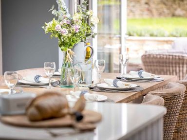 A dining room with a table set for dinner at Lavender Cottage (Stow-on-the-Wold) Cheltenham