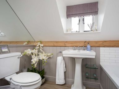 A bathroom with a toilet, washbasin, and window at Lavender Cottage (Stow-on-the-Wold) Cheltenham
