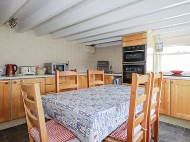 A kitchen with a table and chairs at Kiln Cottage Golant near Tywardreath