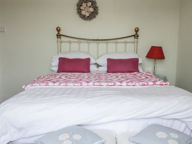 A bedroom with a bed and lamp at Kiln Cottage Golant near Tywardreath