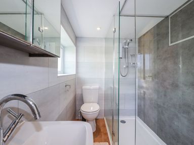 A bathroom with a bathtub, toilet, and shower at Kiln Cottage in Golant near Tywardreath