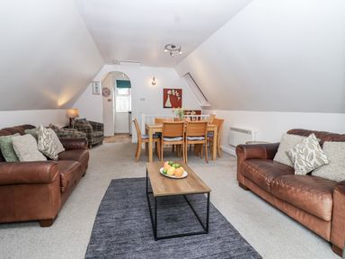 A living room with a sofa and dining area at Valley Lodge 20 in Callington