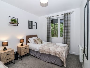 A bedroom with a bed and nightstands at Valley Lodge 20 in Callington