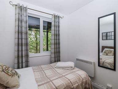 A bedroom with a bed and window at Valley Lodge 20 Callington