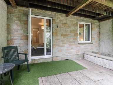 An outdoor seating area with a table and chair at Valley Lodge 20 Callington