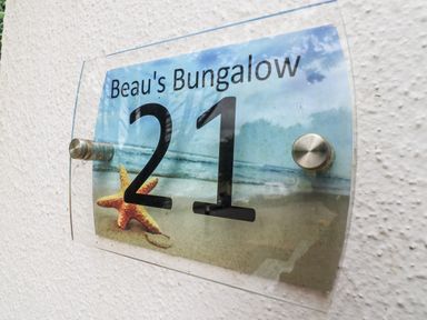 A nameplate displaying Beau's Bungalow 21 with a starfish at Manorcombe 21 Honicombe Holiday Village near Gunnislake