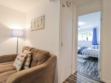 A living room with a sofa and door leading to a bedroom at Manorcombe 21 Honicombe Holiday Village near Gunnislake