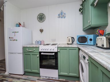 A kitchen with appliances including a refrigerator, oven and microwave at Manorcombe 21 in Honicombe Holiday Village near Gunnislake
