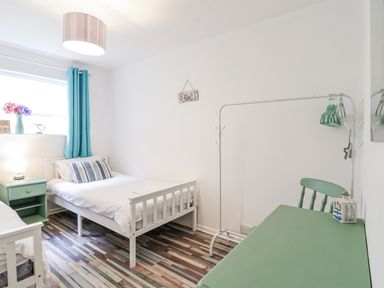 A bedroom with two beds, a desk, and a lamp at Manorcombe 21 Honicombe Holiday Village near Gunnislake