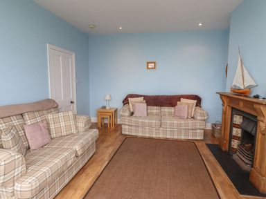 A living room with two sofas and a fireplace at Glen Avon in Seahouses