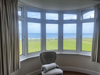 A living room with a view of the sea at Glen Avon in Seahouses