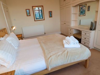 A bedroom with a bed and desk at Glen Avon Seahouses