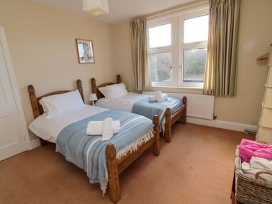 A bedroom with two beds and a window at Glen Avon in Seahouses