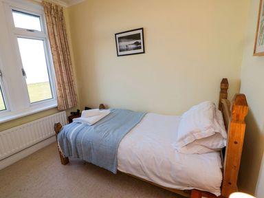 A bedroom with a bed and window at Glen Avon in Seahouses