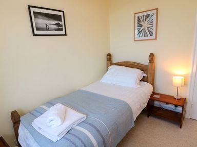 A bedroom with a single bed and lamp at Glen Avon in Seahouses