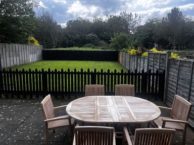 A garden with a wooden table and chairs at Glen Avon in Seahouses