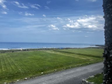 A view of the ocean and grassland at Glen Avon in Seahouses