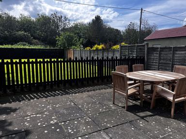 A garden with a wooden table and chairs at Glen Avon in Seahouses