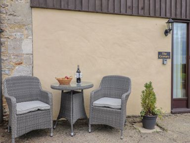 Chairs and table with wine and fruit at The Granary in Wyke Nr Axminster