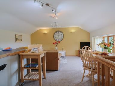 A living room with a sofa and dining area at The Granary Wyke Nr Axminster