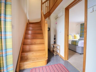 A hallway with a staircase and doorway leading to a bedroom at The Granary in Wyke Nr Axminster