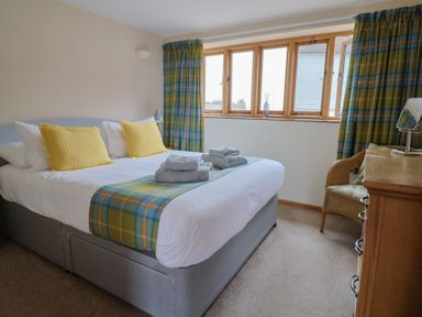 A bedroom with a bed and towels on The Granary in Wyke Nr Axminster