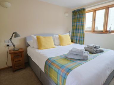 A bedroom with a double bed and a nightstand at The Granary in Wyke Nr Axminster