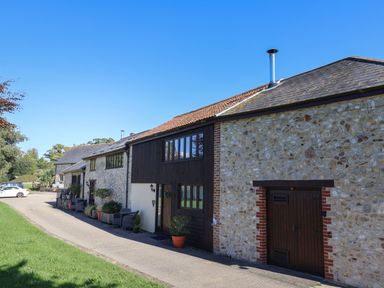A house with stone walls and a driveway at The Granary in Wyke Nr Axminster
