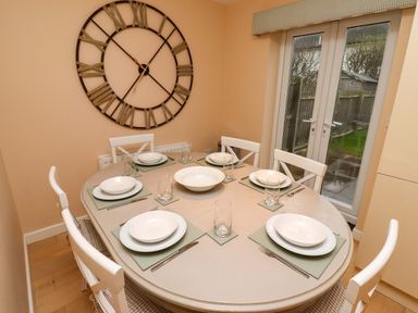 A dining room with a table set for six at High Sea View