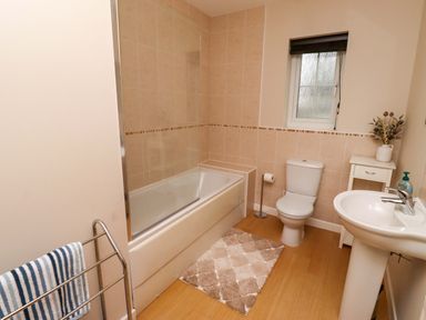 A bathroom with a bathtub, toilet, and sink at High Sea View