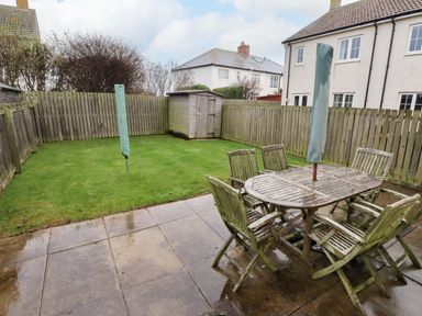 A garden with a table and chairs in a fenced area at High Sea View