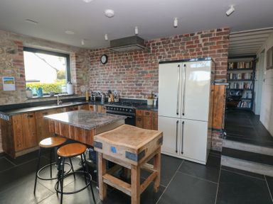 A kitchen with a refrigerator and stove at The Barn in Newport