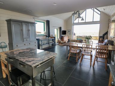 A kitchen with a dining area and island at The Barn in Newport