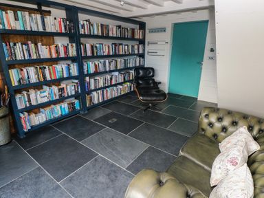 A reading room with bookshelves and a chair at The Barn in Newport