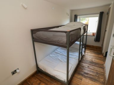 A bedroom with a bunk bed and a window at The Barn in Newport