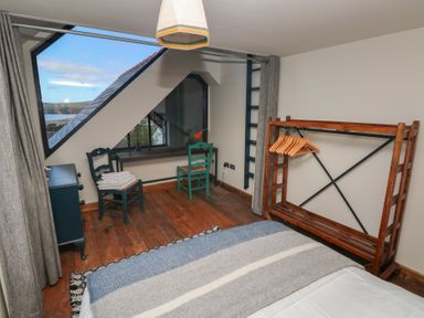 A bedroom with a bed, chairs, and a desk at The Barn in Newport