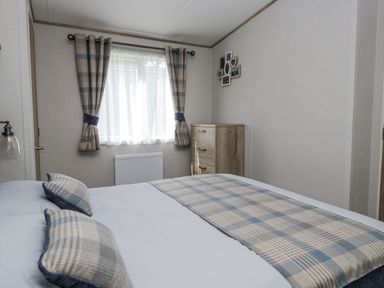 A bedroom with a bed and window at Grasmoor View Lodge