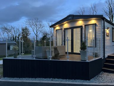 A mobile home with a deck and glass railing at Winscales Rest in Winscales