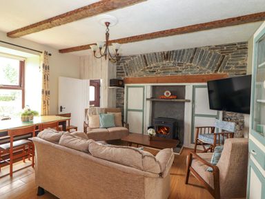 A living room with a fireplace and seating area at The Farmhouse in Tralee, County Kerry