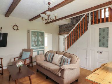 A living room with a sofa and television at The Farmhouse in Tralee, County Kerry